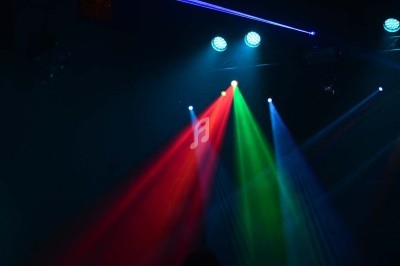 Miniature DJ Chignin (Savoie) - Anim'Fab #18 Un homme chante sur scène avec un micro, éclairé par une lumière rouge dans une ambiance sombre.