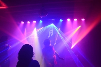 Miniature DJ Chignin (Savoie) - Anim'Fab #20 Un homme chante sur scène avec un micro, éclairé par une lumière rouge dans une ambiance sombre.