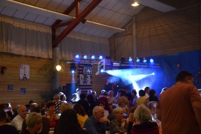 Miniature DJ Chignin (Savoie) - Anim'Fab #3 Un homme chante sur scène avec un micro, éclairé par une lumière rouge dans une ambiance sombre.