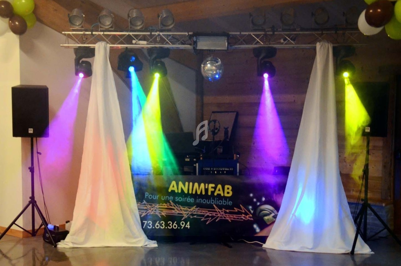 Installation de matériel de sonorisation et éclairage coloré pour une soirée festive en intérieur.