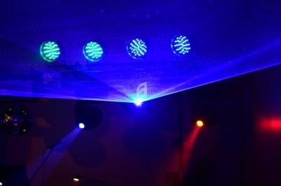 Miniature DJ Chignin (Savoie) - Anim'Fab #30 Un homme chante sur scène avec un micro, éclairé par une lumière rouge dans une ambiance sombre.