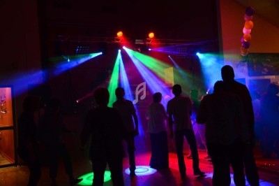 Miniature DJ Chignin (Savoie) - Anim'Fab #32 Un homme chante sur scène avec un micro, éclairé par une lumière rouge dans une ambiance sombre.