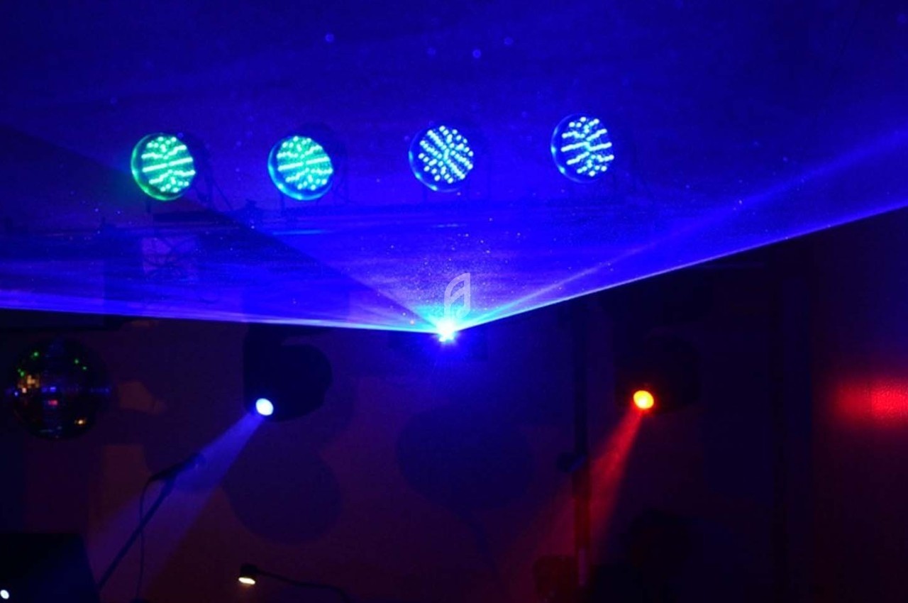 Effets lumineux colorés avec faisceaux laser bleus et spots rouges dans une ambiance sombre.