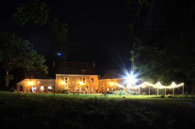 Douche à l'italienne avec paroi vitrée, carrelage beige et motifs, meuble en bois clair et miroir au mur.