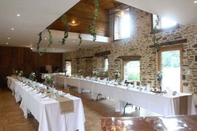 Douche à l'italienne avec paroi vitrée, carrelage beige et motifs, meuble en bois clair et miroir au mur.