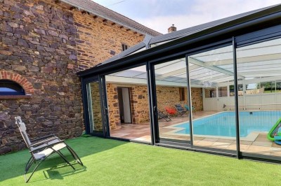 Douche à l'italienne avec paroi vitrée, carrelage beige et motifs, meuble en bois clair et miroir au mur.