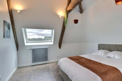 Douche à l'italienne avec paroi vitrée, carrelage beige et motifs, meuble en bois clair et miroir au mur.