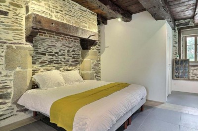 Douche à l'italienne avec paroi vitrée, carrelage beige et motifs, meuble en bois clair et miroir au mur.