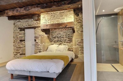 Douche à l'italienne avec paroi vitrée, carrelage beige et motifs, meuble en bois clair et miroir au mur.