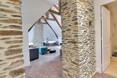 Douche à l'italienne avec paroi vitrée, carrelage beige et motifs, meuble en bois clair et miroir au mur.