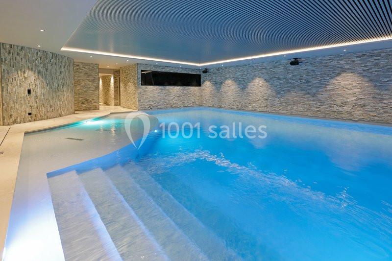 Location salle Nivelles (Brabant wallon) - Hôtel Nivelles Sud #19 Piscine intérieure moderne avec éclairage tamisé, murs en pierre et plafond à lames.