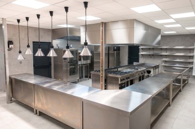 Miniature Location salle Saint-Laurent-Blangy (Pas-de-Calais) - Elegance Events #17 Cuisine professionnelle moderne avec équipements en inox, éclairage suspendu et fourneaux sous une hotte d'extraction.