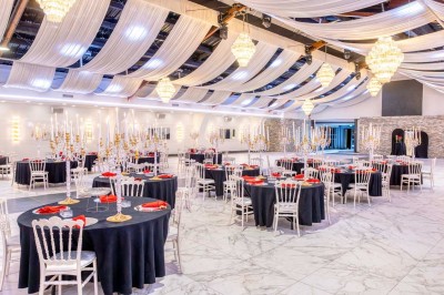 Miniature Location salle Saint-Laurent-Blangy (Pas-de-Calais) - Elegance Events #4 Cuisine professionnelle moderne avec équipements en inox, éclairage suspendu et fourneaux sous une hotte d'extraction.