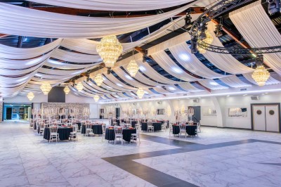 Miniature Location salle Saint-Laurent-Blangy (Pas-de-Calais) - Elegance Events #2 Cuisine professionnelle moderne avec équipements en inox, éclairage suspendu et fourneaux sous une hotte d'extraction.