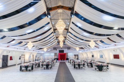 Miniature Location salle Saint-Laurent-Blangy (Pas-de-Calais) - Elegance Events #7 Cuisine professionnelle moderne avec équipements en inox, éclairage suspendu et fourneaux sous une hotte d'extraction.