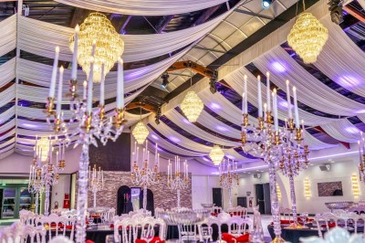 Miniature Location salle Saint-Laurent-Blangy (Pas-de-Calais) - Elegance Events #8 Cuisine professionnelle moderne avec équipements en inox, éclairage suspendu et fourneaux sous une hotte d'extraction.