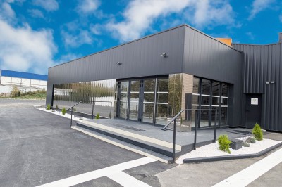 Miniature Location salle Saint-Laurent-Blangy (Pas-de-Calais) - Elegance Events #3 Cuisine professionnelle moderne avec équipements en inox, éclairage suspendu et fourneaux sous une hotte d'extraction.