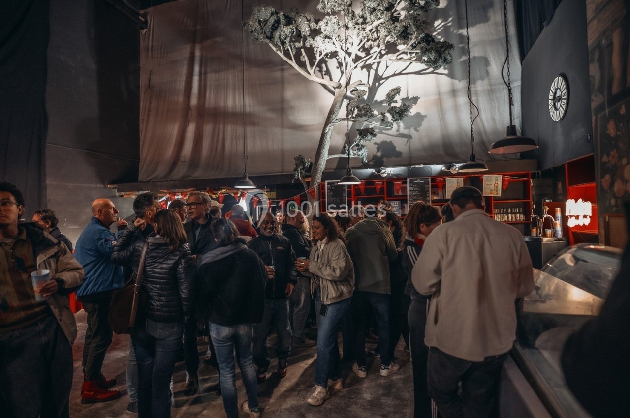 Groupe de personnes rassemblées dans un espace intérieur avec un décor d'arbre éclairé et un comptoir en arrière-plan.