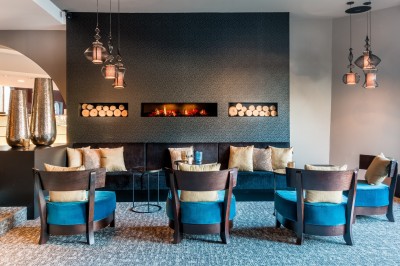 Femme allongée recevant un soin du visage avec un bandeau blanc, une personne nettoie sa peau avec des cotons.