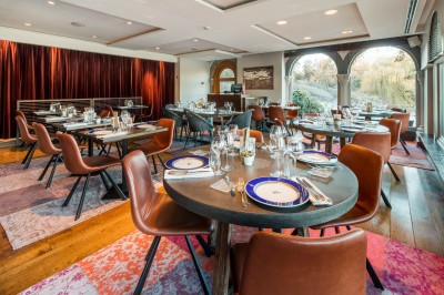 Femme allongée recevant un soin du visage avec un bandeau blanc, une personne nettoie sa peau avec des cotons.