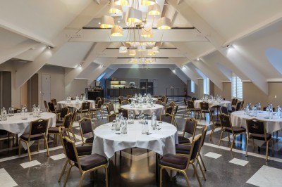 Femme allongée recevant un soin du visage avec un bandeau blanc, une personne nettoie sa peau avec des cotons.