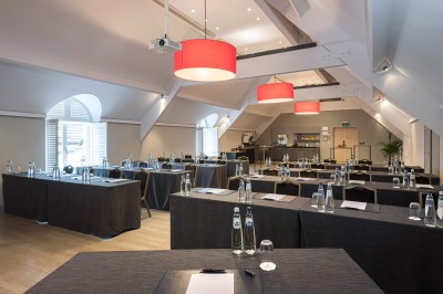 Femme allongée recevant un soin du visage avec un bandeau blanc, une personne nettoie sa peau avec des cotons.