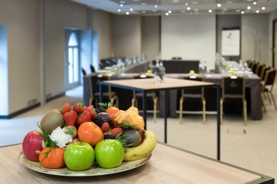 Femme allongée recevant un soin du visage avec un bandeau blanc, une personne nettoie sa peau avec des cotons.