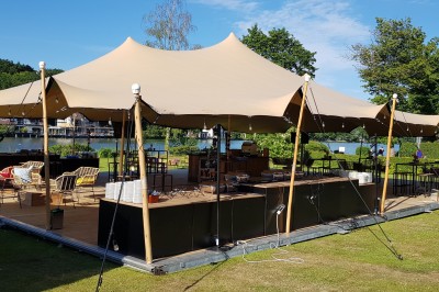Femme allongée recevant un soin du visage avec un bandeau blanc, une personne nettoie sa peau avec des cotons.