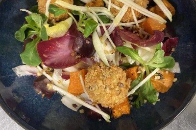 Miniature Location salle Rueil-Malmaison (Hauts-de-Seine) - Espace Laplace #19 Assiette de velouté orange garnie de croûtons dorés et de traits de crème blanche, servie sur une table en inox.