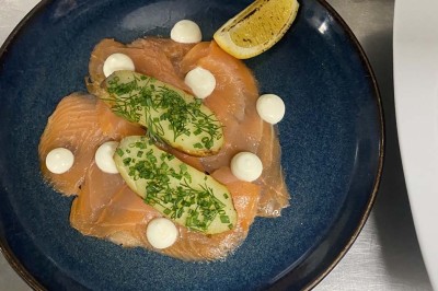 Miniature Location salle Rueil-Malmaison (Hauts-de-Seine) - Espace Laplace #22 Assiette de velouté orange garnie de croûtons dorés et de traits de crème blanche, servie sur une table en inox.