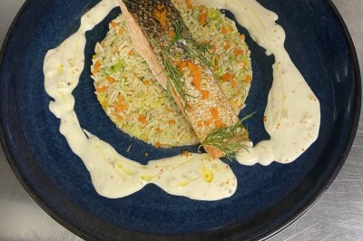 Miniature Location salle Rueil-Malmaison (Hauts-de-Seine) - Espace Laplace #23 Assiette de velouté orange garnie de croûtons dorés et de traits de crème blanche, servie sur une table en inox.