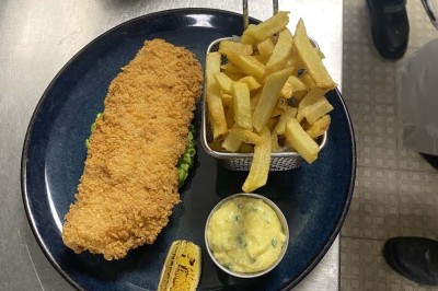Miniature Location salle Rueil-Malmaison (Hauts-de-Seine) - Espace Laplace #25 Assiette de velouté orange garnie de croûtons dorés et de traits de crème blanche, servie sur une table en inox.