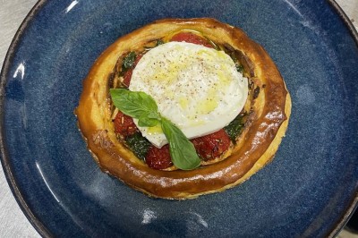 Miniature Location salle Rueil-Malmaison (Hauts-de-Seine) - Espace Laplace #27 Assiette de velouté orange garnie de croûtons dorés et de traits de crème blanche, servie sur une table en inox.