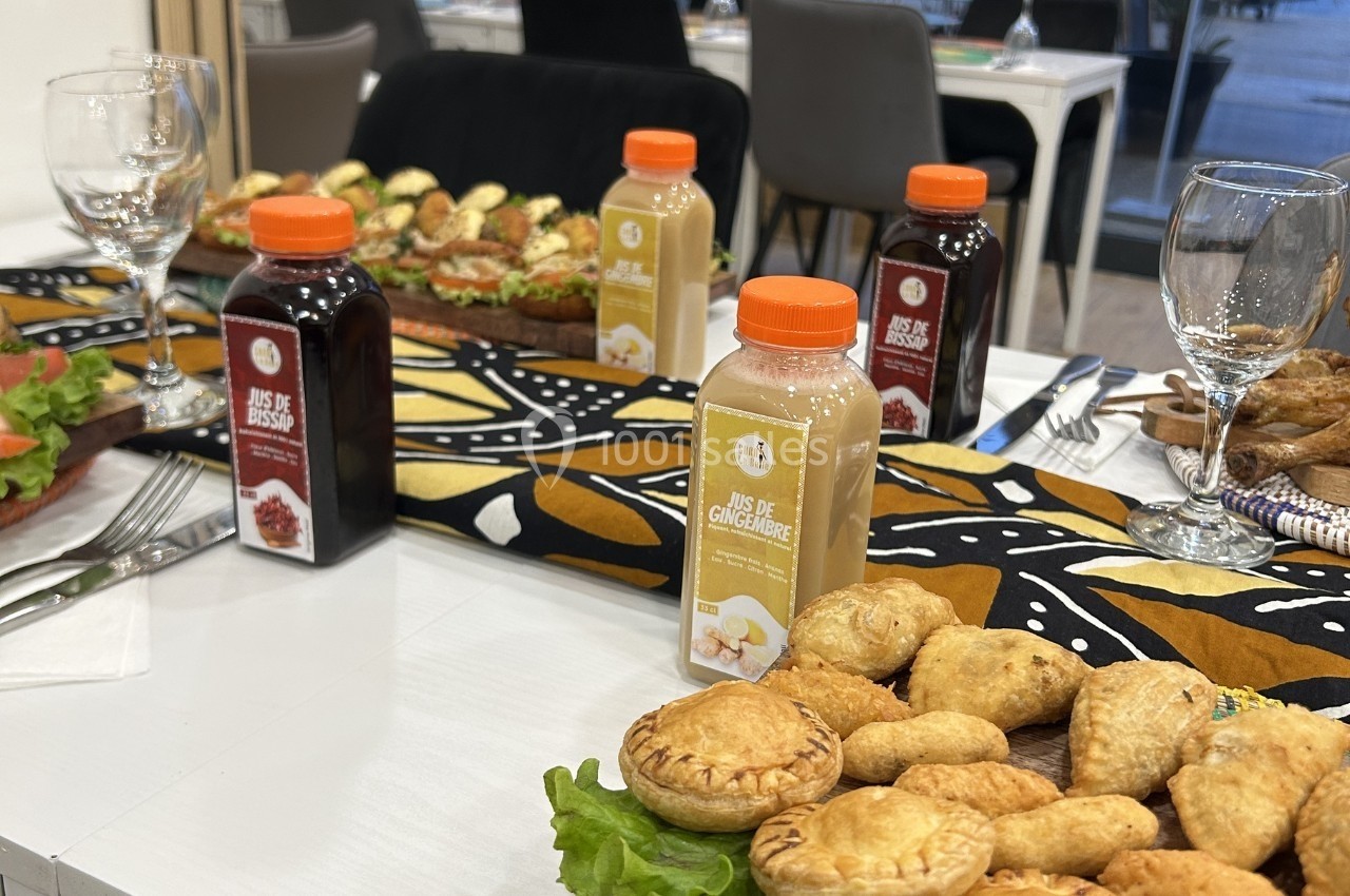Boissons en bouteilles et assortiments de pâtisseries disposés sur une table décorée de motifs colorés.