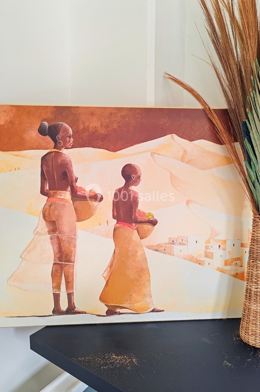 Peinture représentant deux personnes portant des paniers dans un paysage désertique, avec des dunes et un village au loin.