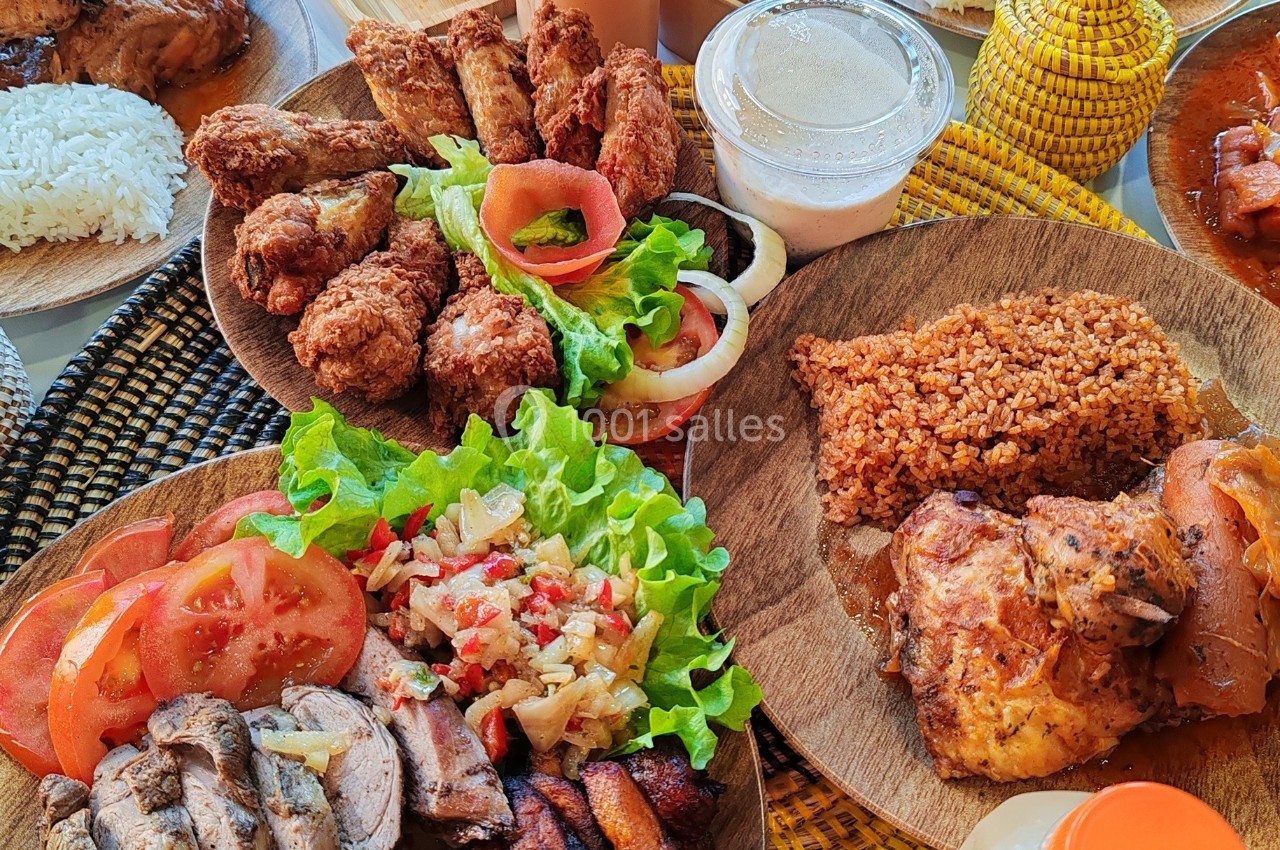 Assortiment de plats comprenant du poulet frit, du riz, des légumes frais, de la sauce et des accompagnements variés.