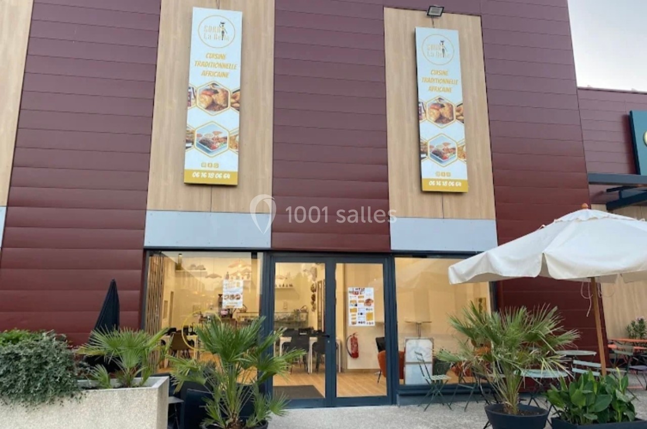 Façade d'un restaurant avec des panneaux affichant ’Cuisine traditionnelle africaine’, entourée de plantes et d'une terrasse.