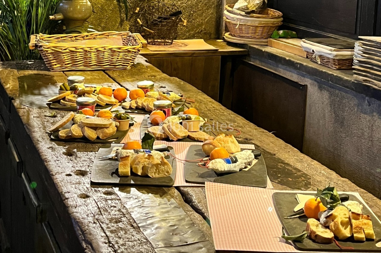 Plateaux de dégustation avec fromages, fruits, pain et condiments disposés sur une table en bois rustique.