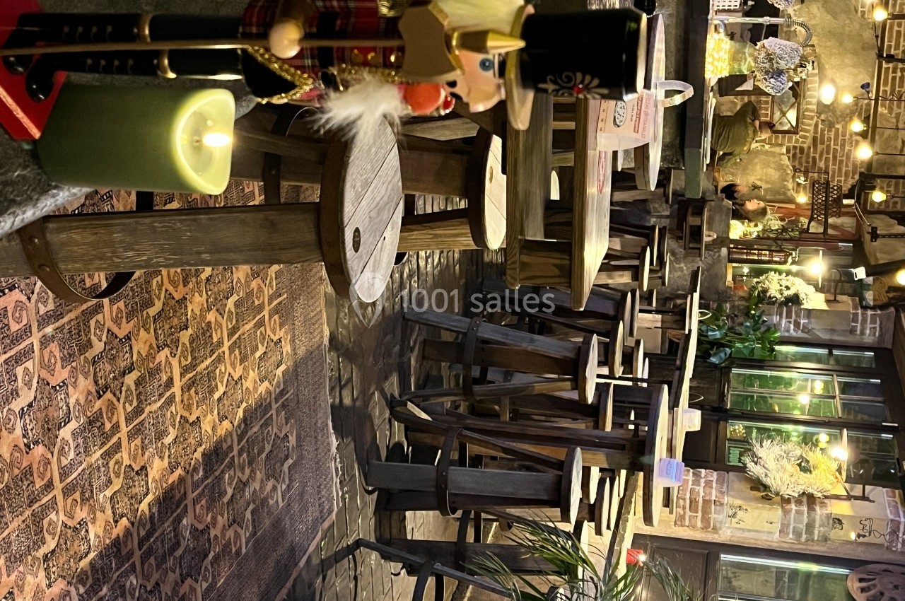 Soldat casse-noisette en bois près d'une bougie allumée, entouré de tables et chaises dans un décor chaleureux.