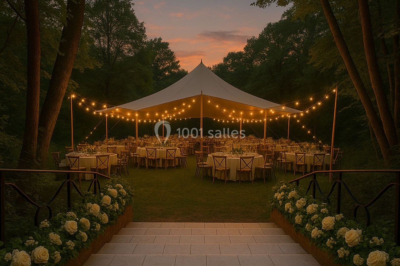 Tente éclairée par des guirlandes lumineuses au crépuscule, entourée de tables dressées dans un cadre verdoyant.