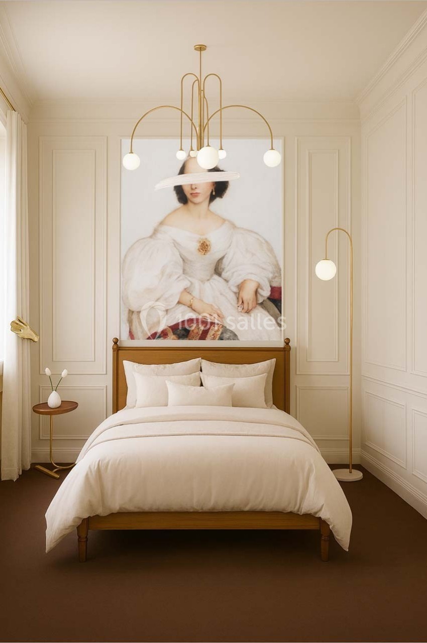 Chambre élégante avec lit double, décoration minimaliste, lustre moderne et grand tableau mural représentant une femme.