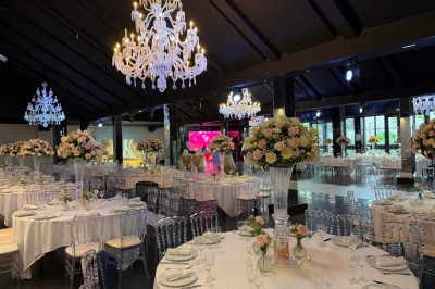 Miniature Traiteur Paris 8 (Paris) - Les Trois Soeurs Traiteur #3 Table de réception élégamment dressée avec chandeliers, fleurs pourpres et vaisselle raffinée dans une salle lumineuse.