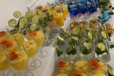 Miniature Traiteur Paris 8 (Paris) - Les Trois Soeurs Traiteur #14 Table de réception élégamment dressée avec chandeliers, fleurs pourpres et vaisselle raffinée dans une salle lumineuse.