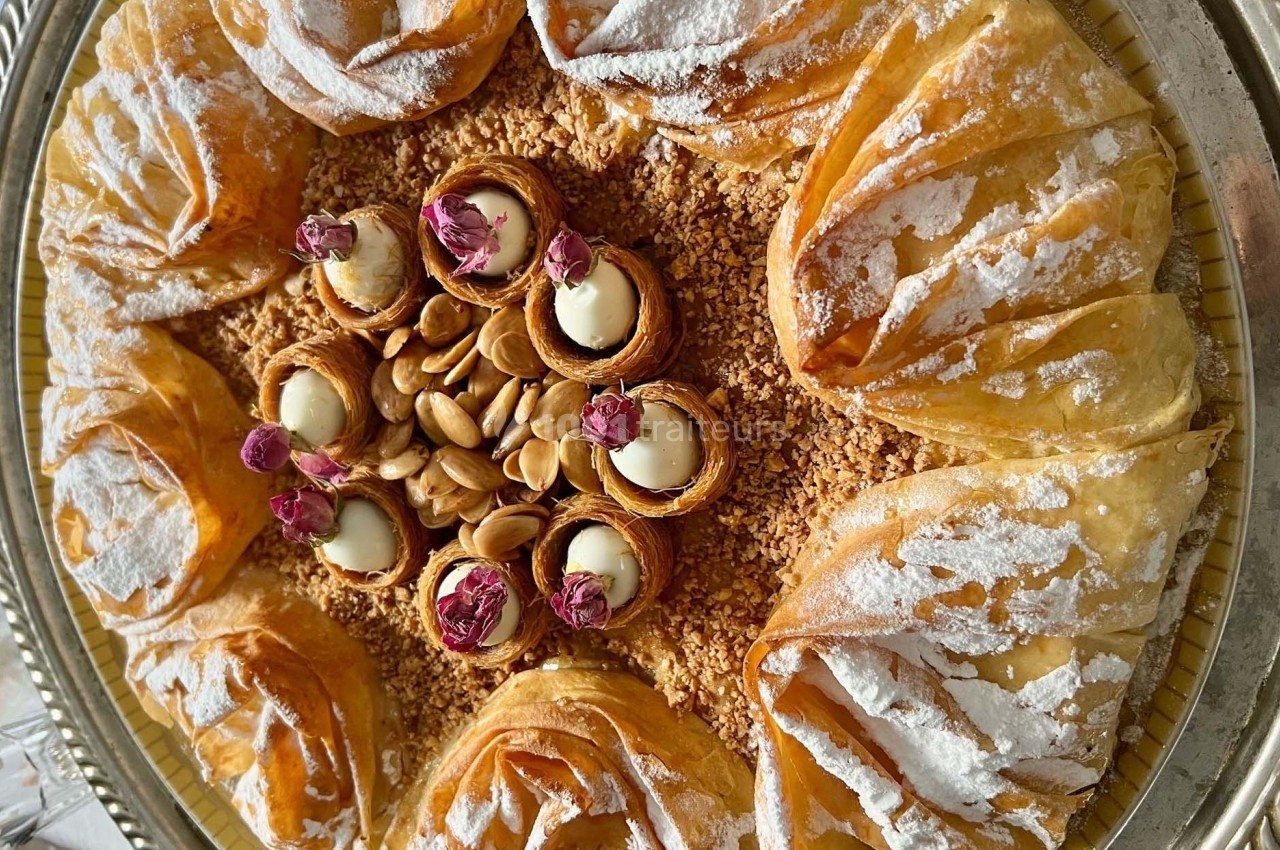 Assortiment de pâtisseries orientales en pâte filo garnies d'amandes, de crème et décorées de roses séchées.