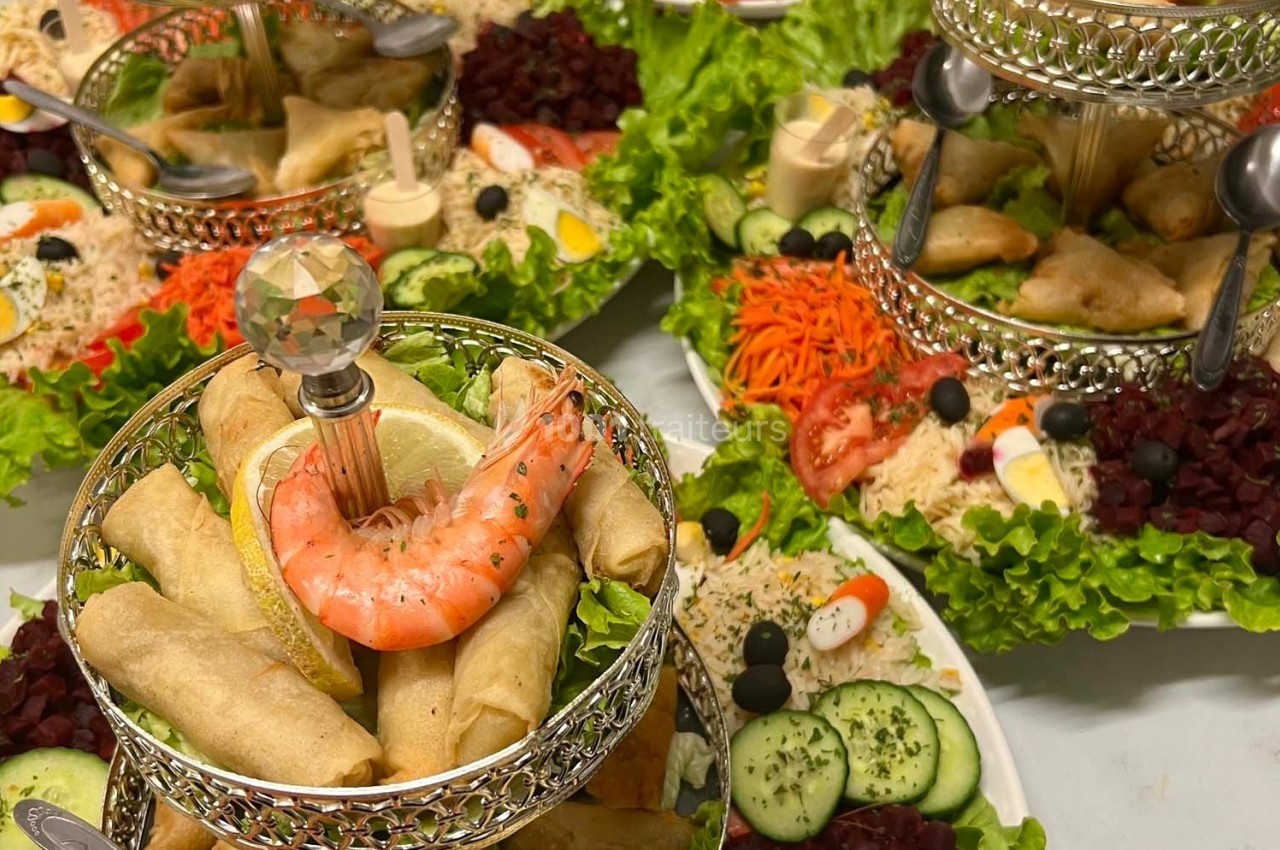 Plateaux garnis de rouleaux de printemps, crevettes, légumes frais et sauces, présentés sur des étages décoratifs.