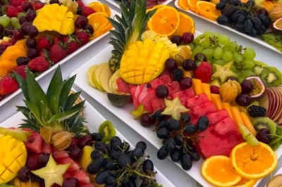 Miniature Traiteur Paris 8 (Paris) - Les Trois Soeurs Traiteur #29 Table de réception élégamment dressée avec chandeliers, fleurs pourpres et vaisselle raffinée dans une salle lumineuse.