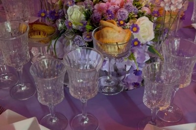 Miniature Traiteur Paris 8 (Paris) - Les Trois Soeurs Traiteur #33 Table de réception élégamment dressée avec chandeliers, fleurs pourpres et vaisselle raffinée dans une salle lumineuse.