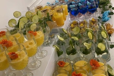 Miniature Traiteur Paris 8 (Paris) - Les Trois Soeurs Traiteur #38 Table de réception élégamment dressée avec chandeliers, fleurs pourpres et vaisselle raffinée dans une salle lumineuse.