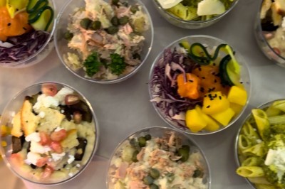 Table de réception élégamment dressée avec chandeliers, fleurs pourpres et vaisselle raffinée dans une salle lumineuse.