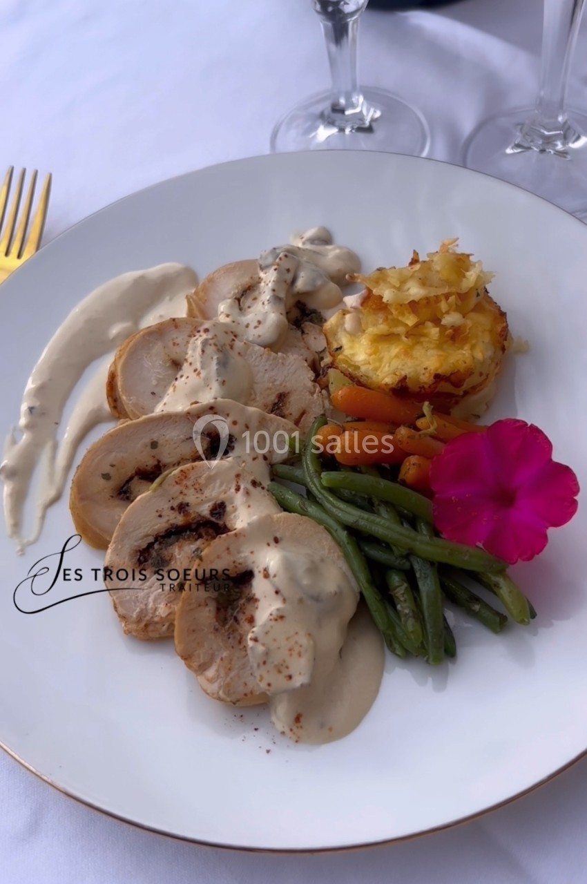 Assiette de poulet sauce crème, haricots verts, carottes, gratin de pommes de terre et fleur comestible en décoration.